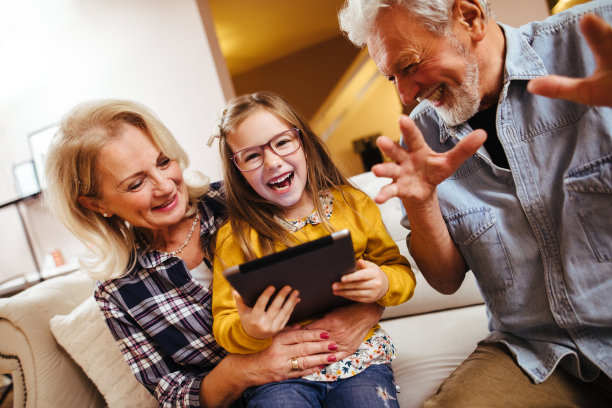 祖父母和孙女在家里使用数字平板电脑图片下载