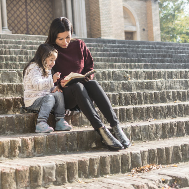 星期天，母亲和女儿在教堂前朗读这本书中的故事图片下载