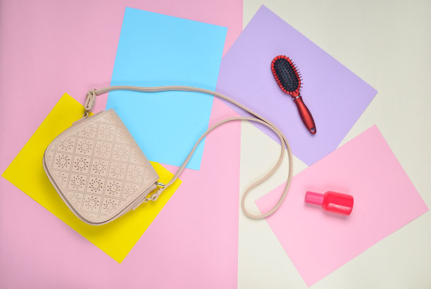 皮包，梳子，香水瓶，色彩柔和的背景。极简主义。俯视图图片下载