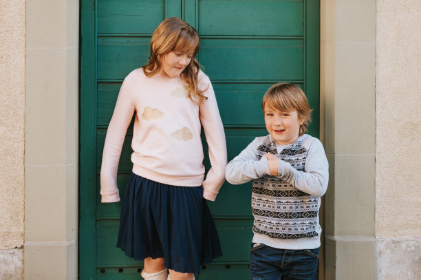 户外肖像两个有趣的孩子一起玩，穿着时尚的运动衫图片下载