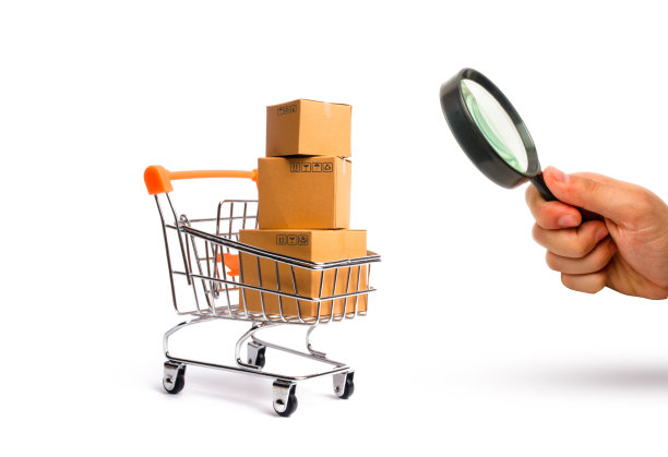 放大镜是看超市购物车里的箱子，商品:买卖商品和服务的概念，贸易和营业额。进出口，购买力。图片下载