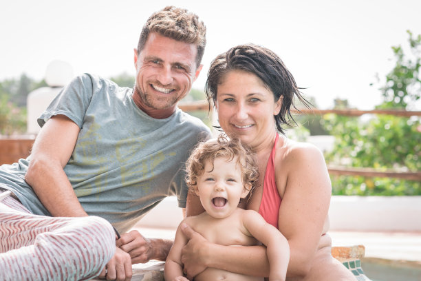 小女孩和她的父母一起笑图片下载