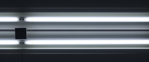 天花板与发光的平行荧光灯管的特写照片。抽象的发光背景的主题，现代建筑，室内或技术。图片下载