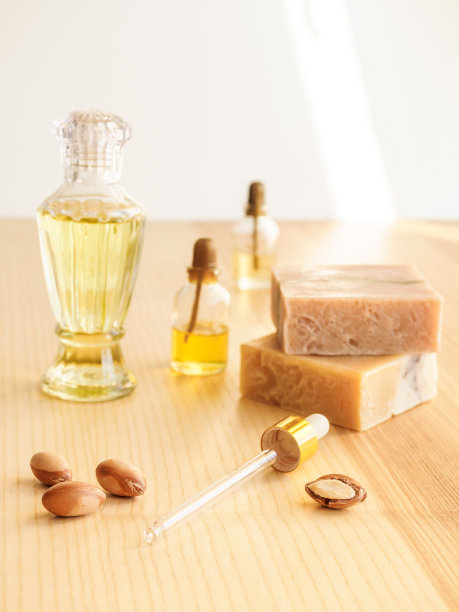 装化妆品油的瓶子和坚果。化妆品的意思。食品产品。在木制背景上加入摩洛哥坚果油和手工肥皂图片下载