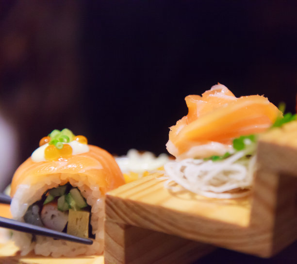 日本鲜鱼菜肴菜单，鲑鱼寿司和生鱼片搭配装饰在传统的日本餐厅的木制台阶上。营养丰富的健康食品，美味的膳食理念图片下载