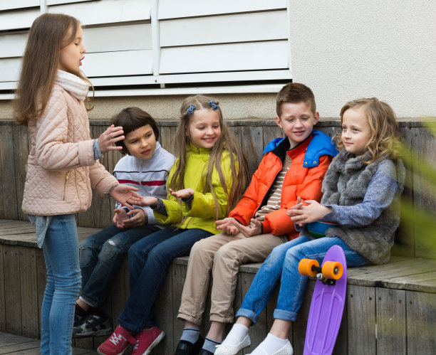 一群孩子坐在长凳上玩耍图片下载