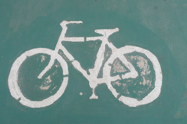 绿色道路上的自行车标志是健康和能源的概念。图片下载