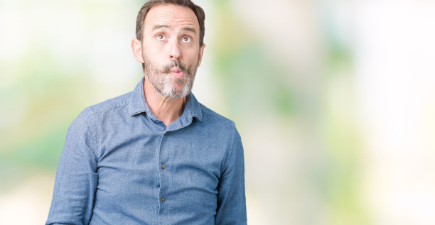 英俊的中年优雅的高级男子在孤立的背景，使鱼脸与嘴唇，疯狂和滑稽的姿态。有趣的表情。图片下载