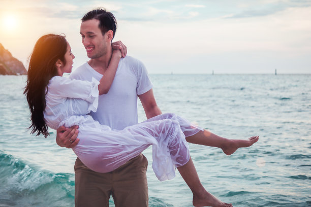 幸福的蜜月夫妇浪漫的爱情在海滩日落。图片下载