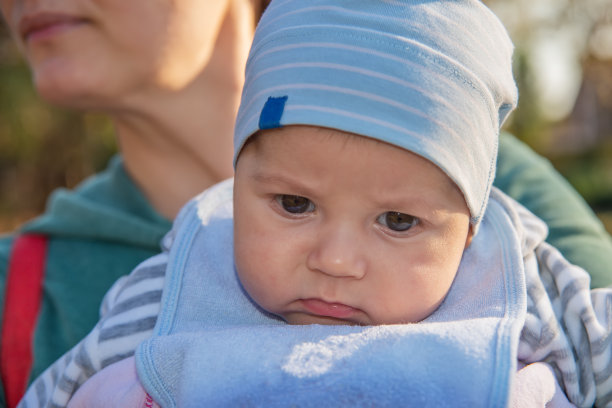 刚出生的婴儿在他妈妈的手中。宝宝第一次在公园里。图片下载