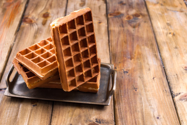 木制背景上的比利时华夫饼。家庭早餐自制糕点。最小的组合。放置文字在照片上。图片下载