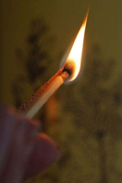 点燃一根香的火柴。图片下载