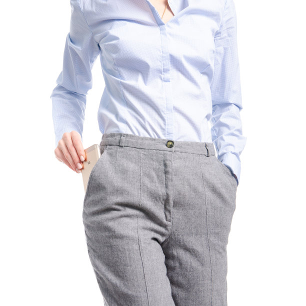 穿着灰色裤子和蓝色衬衫的女人手里拿着智能手机的宏图片下载