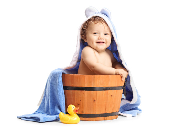 可爱的小男孩赤裸着身子躺在木桶里，头上盖着一条毛巾图片下载