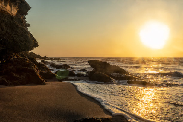 荒凉的纳米比海滩上美丽的日落。照片拍摄的水与悬崖和岩石。非洲。安哥拉。图片下载