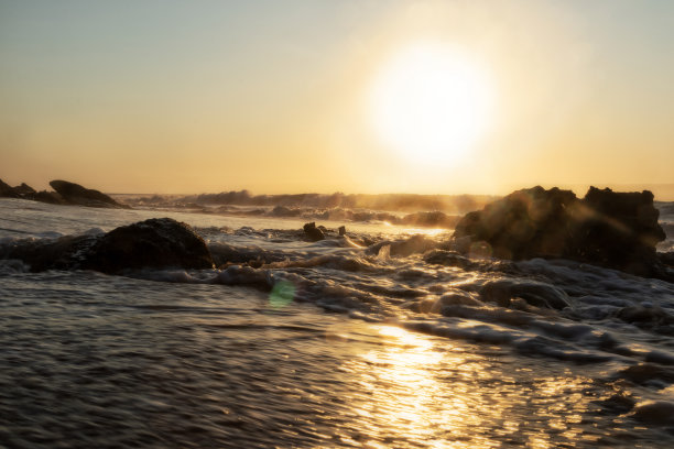 荒凉的纳米比海滩上美丽的日落。照片拍摄的水与悬崖和岩石。非洲。安哥拉。图片下载