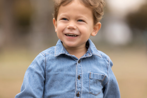 漂亮的小男孩在户外微笑。图片下载