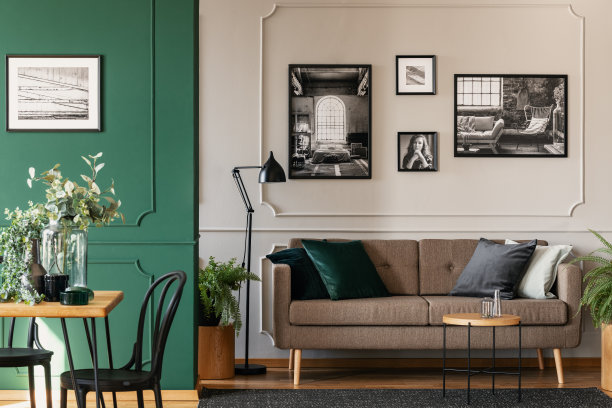 灰色墙壁上的黑白照片别致的客厅和餐厅内部，棕色的沙发和木桌图片下载