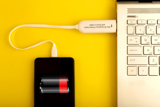 通过充电宝为智能手机充电，彩色背景屏幕上显示电池图标俯视图图片下载