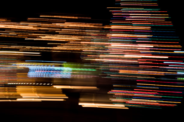 在运动中的多色城市灯光光束的抽象，移动多彩的线条或光画LED建筑抽象在繁忙的城市灯光轨迹背景。图片下载