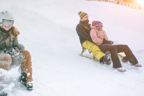 快乐的朋友在雪山上玩雪橇-年轻的千禧一代在白色周假期的雪橇比赛-冬季运动和旅游概念-关注正确的夫妇的脸图片下载