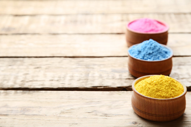 五颜六色的胡里粉装在棕色的木桌上图片下载