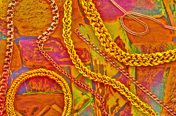 时尚的金链在优雅的丝绸背景。图片下载