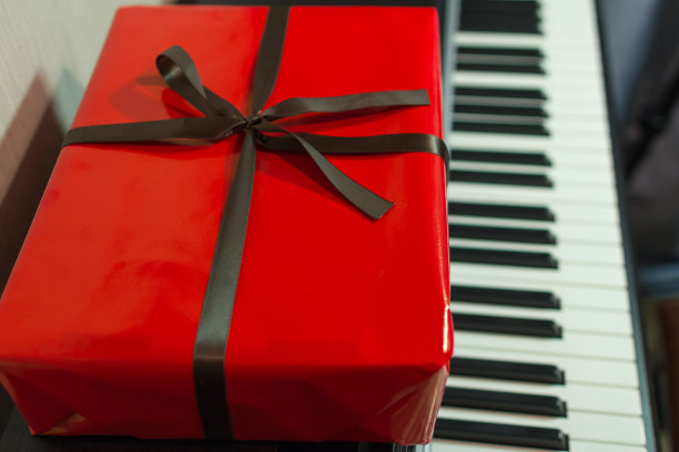 钢琴上放着红色的大礼盒。图片下载