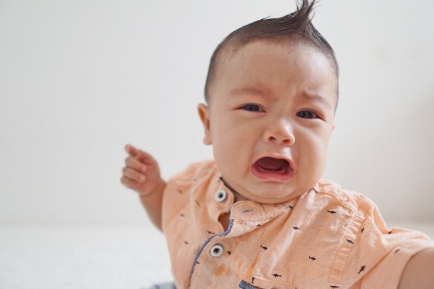 哭泣的婴儿男孩特写照片与白色背景图片下载