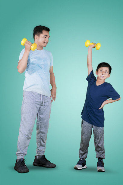 父亲和孩子在演播室举着哑铃图片下载