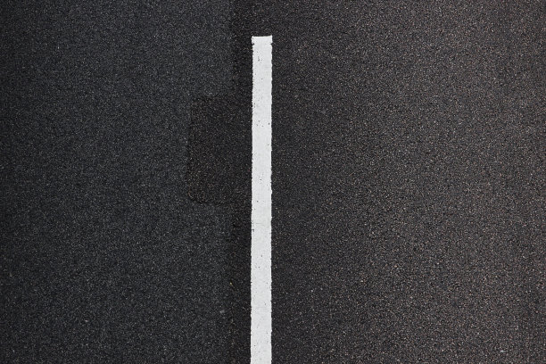 沥青路面上的道路标记。分隔交通车道的虚线。摘要纹理的主题背景交通，公路法规，道路安全和车辆规则。图片下载