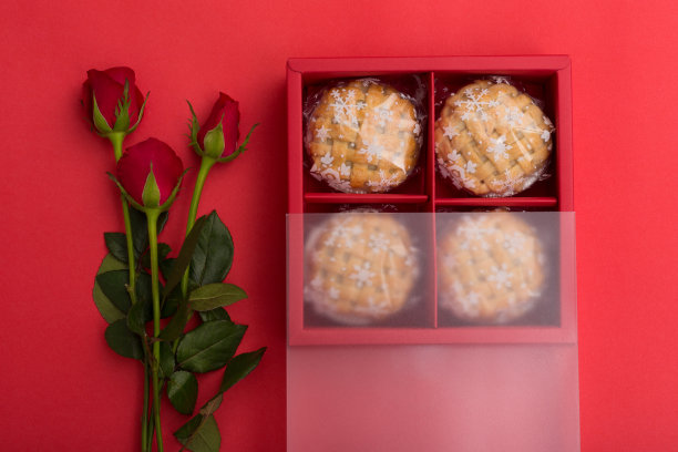 红色背景上的红玫瑰和馅饼图片下载