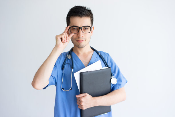 严肃的年轻男医生拿着文件夹和文件图片下载