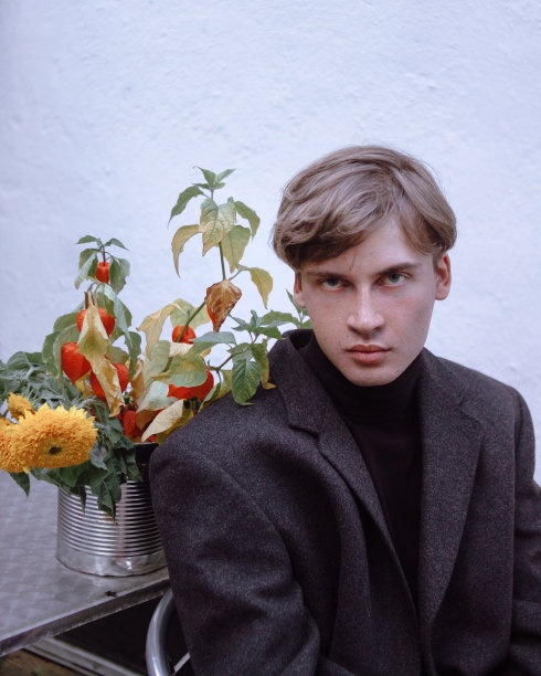 年轻漂亮的男人穿着带花的夹克图片下载