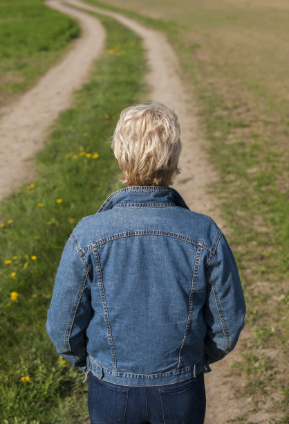 女人看着乡间蜿蜒的道路。图片下载