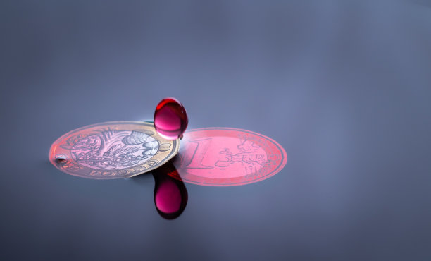 红色水滴溅在硬币上图片下载