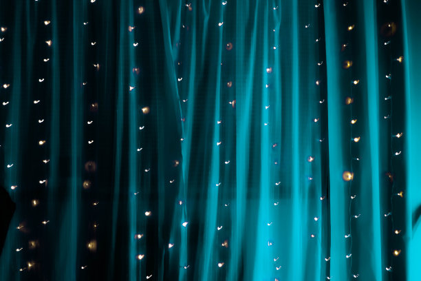 水蓝色的照明窗帘上串仙女灯的长时间曝光的柔软图片图片下载