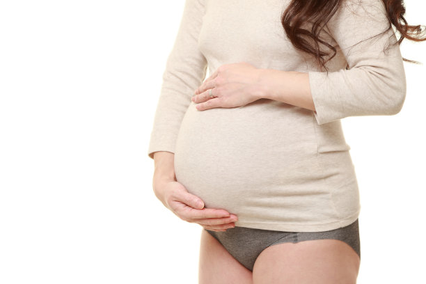 穿着象牙色衬衫的孕妇摸着自己的肚子图片下载
