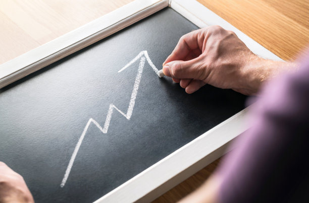 经济增长。对经济中收入或利润增长的预测。报告财务状况。成功的商人在黑板上画递增图。销售上升。图片下载