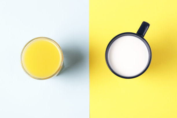 一个在黄色和蓝色背景上有果汁和牛奶的杯子，俯视图图片下载