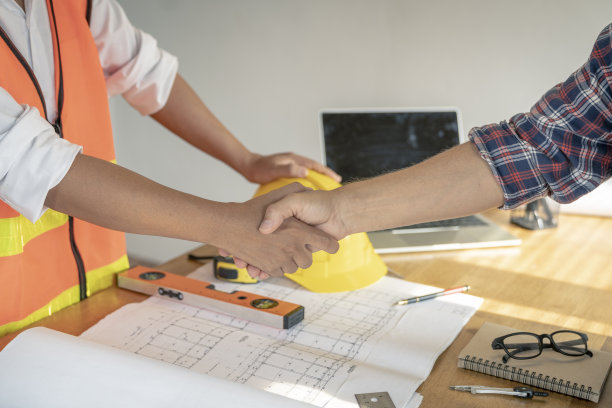 建筑师团队在办公室讨论房屋或建筑物的问题，平面图仅为库存照片而伪造。图片下载