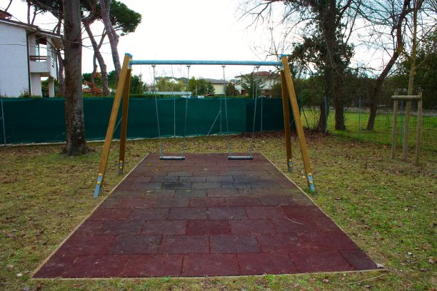 儿童操场上的双座秋千。孩子们不在那里。这个地方空无一人。这一天是悲伤和灰色的。孤独和被抛弃。游戏对孩子们。图片下载