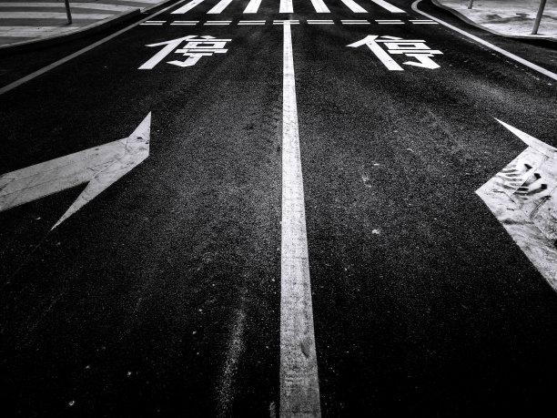 停车标志涂在柏油路上，标志的意思是“停车”。有停车标志的城市道路图片下载