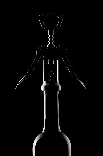 黑色背景上的开瓶器和酒瓶图片下载