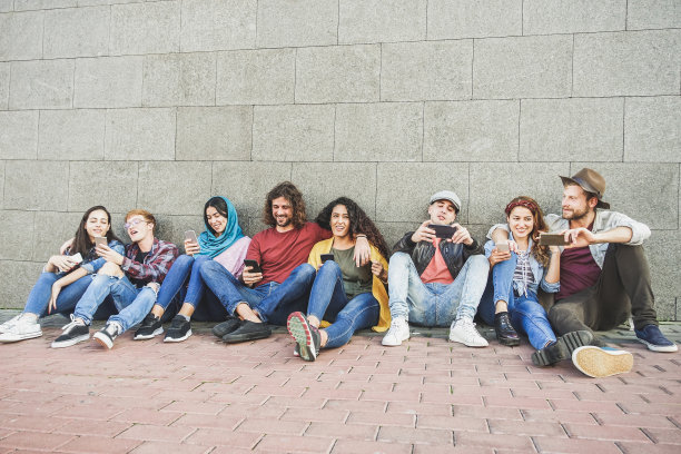 一群使用智能手机的千禧一代朋友-沉迷于新技术趋势的人-青年、z一代、社交网络和友谊的概念-主要集中在中心面孔图片下载