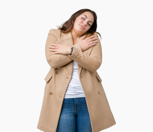 美丽的大码少女穿着冬衣越过孤立的背景拥抱着自己快乐和积极，微笑着自信。爱自己，关心自己图片下载