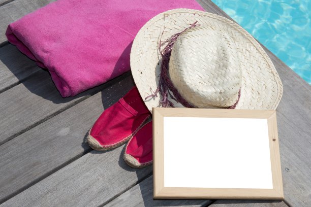 在夏天的泳池边，戴着粉红色的毛巾，用空白的黑板图片下载