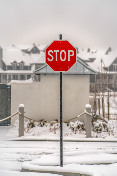 犹他州黎明时分，一条被雪覆盖的道路上的停车标志图片下载