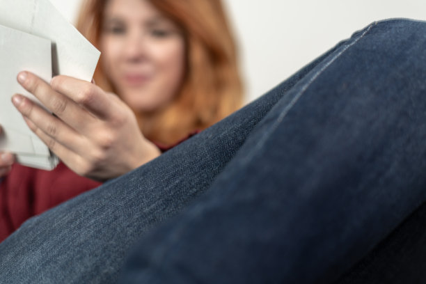 腿的特写，在沙发上翻看旧照片图片下载