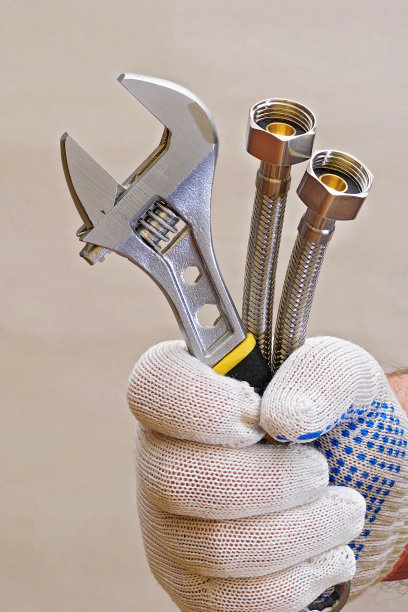 管道工手里拿着可调节扳手和软管，就像捧花束一样图片下载